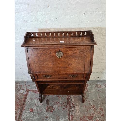 365 - An early 20th century oak bureau with fretwork galleried top, fall front, single drawer and two lowe... 