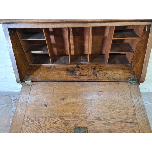 365 - An early 20th century oak bureau with fretwork galleried top, fall front, single drawer and two lowe... 