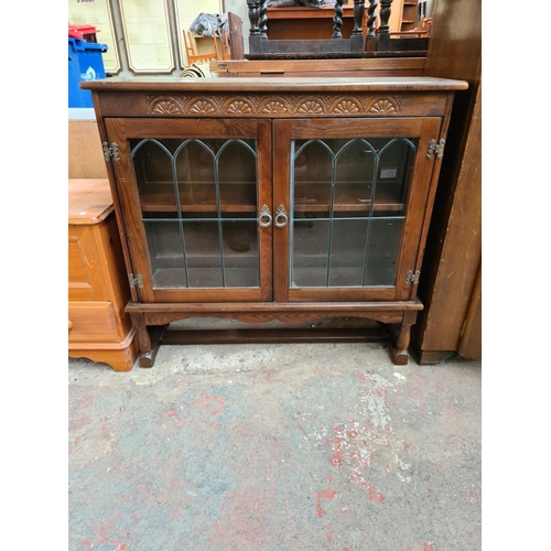 368 - An oak bookcase with two leaded glass doors and two internal shelves - approx. 92cm high x 96cm wide... 