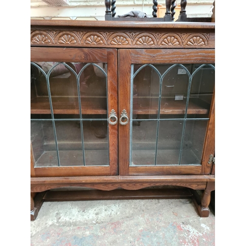 368 - An oak bookcase with two leaded glass doors and two internal shelves - approx. 92cm high x 96cm wide... 