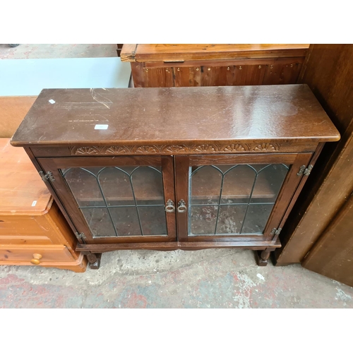 368 - An oak bookcase with two leaded glass doors and two internal shelves - approx. 92cm high x 96cm wide... 