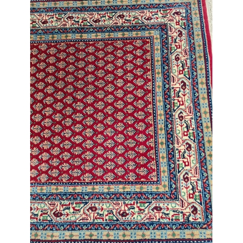 369 - A Persian style red tasselled rug - approx. 165cm x 95cm