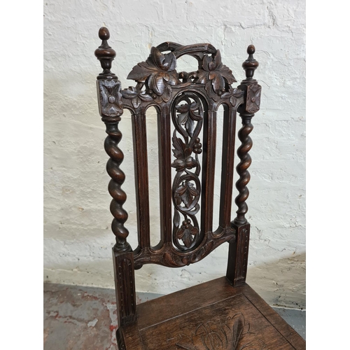 373 - A pair of 19th century heavily carved oak dining chairs with barley twist columns and floral design ... 