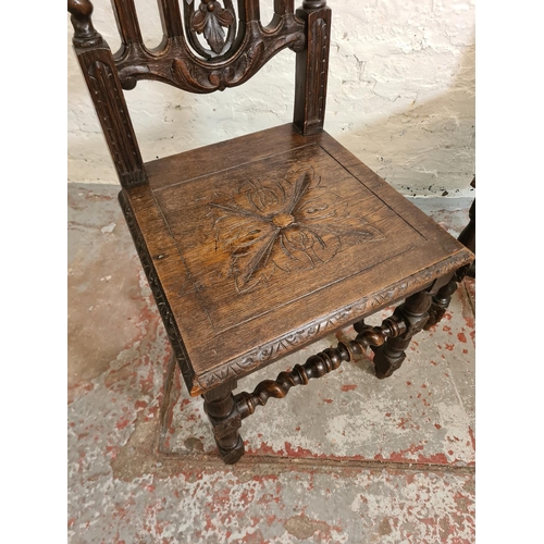 373 - A pair of 19th century heavily carved oak dining chairs with barley twist columns and floral design ... 