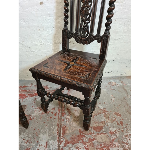 373 - A pair of 19th century heavily carved oak dining chairs with barley twist columns and floral design ... 