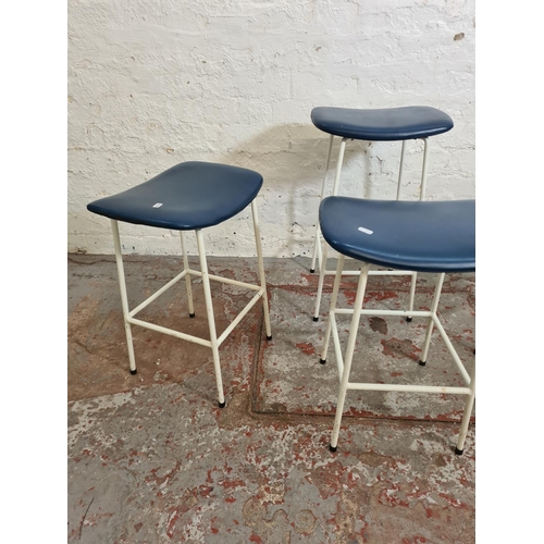 391 - Four 1950s Kandya white tubular metal and blue vinyl stools designed by Frank Guille - three approx.... 