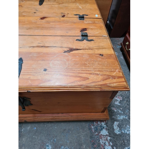 405 - A modern pine square storage coffee table with two hinged lids and cast iron fittings - approx. 42cm... 