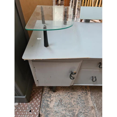 406 - A mid 20th century grey painted dressing table with two central drawers, two outer cupboard doors an... 