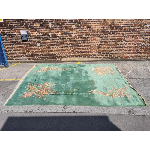 307 - A large green floral patterned rug - approx. 336cm x 460cm