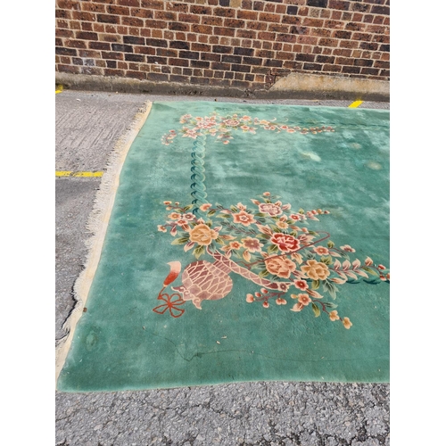 307 - A large green floral patterned rug - approx. 336cm x 460cm