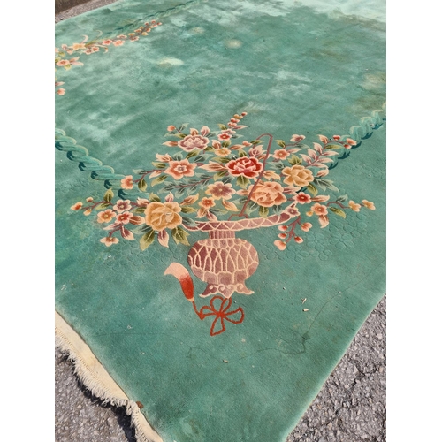 307 - A large green floral patterned rug - approx. 336cm x 460cm