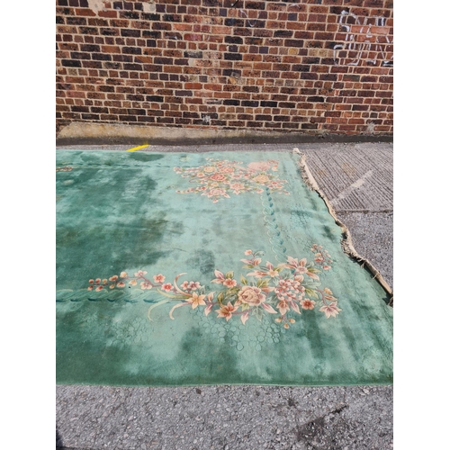 307 - A large green floral patterned rug - approx. 336cm x 460cm