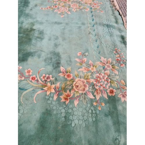 307 - A large green floral patterned rug - approx. 336cm x 460cm