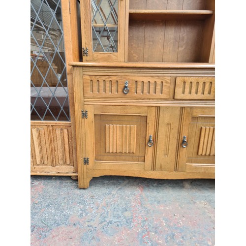 293 - An Agincourt oak dresser with two upper leaded glass doors, two drawers and two lower cupboard doors... 