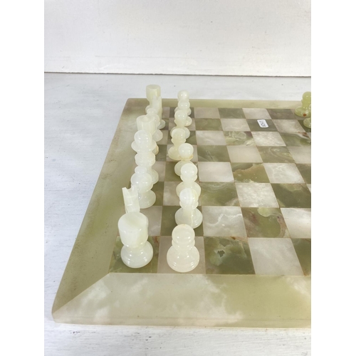 71 - An onyx thirty two piece chess set - board approx. 40.5cm²