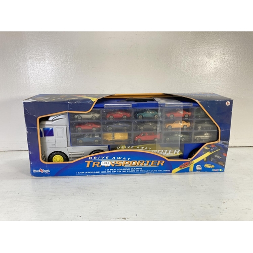 89 - A boxed Time 4 Toys Drive-Away Transporter artic truck with two loading ramps and 15 various diecast... 