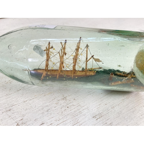 182 - A vintage scratch built ship in a bottle depicting a lighthouse scene - bottle approx. 36cm long