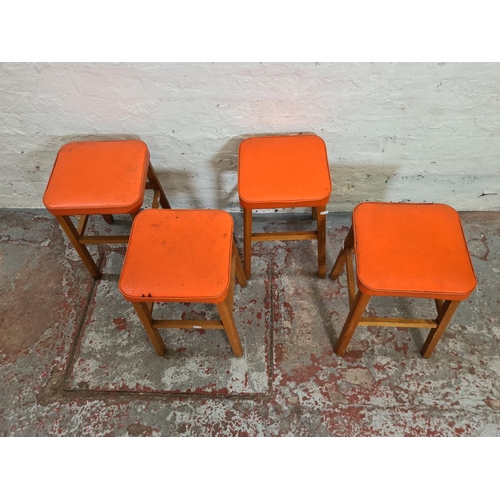 421 - Four mid 20th century orange vinyl and beech stools - approx. 48cm high x 30cm²