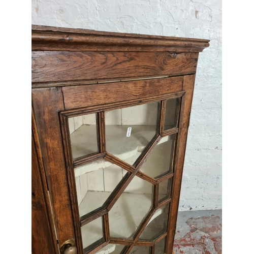 427 - A George III oak astral glazed wall mountable corner cabinet - approx. 99cm high x 64cm wide x 37cm ... 