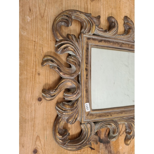 489 - A gilt framed wall mirror with acanthus leaf design - approx. 66cm high x 46cm wide