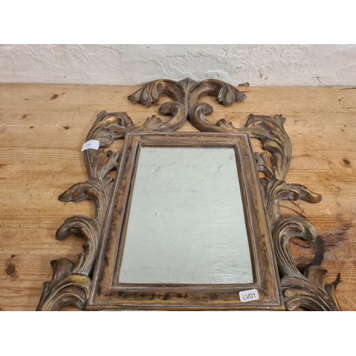 489 - A gilt framed wall mirror with acanthus leaf design - approx. 66cm high x 46cm wide