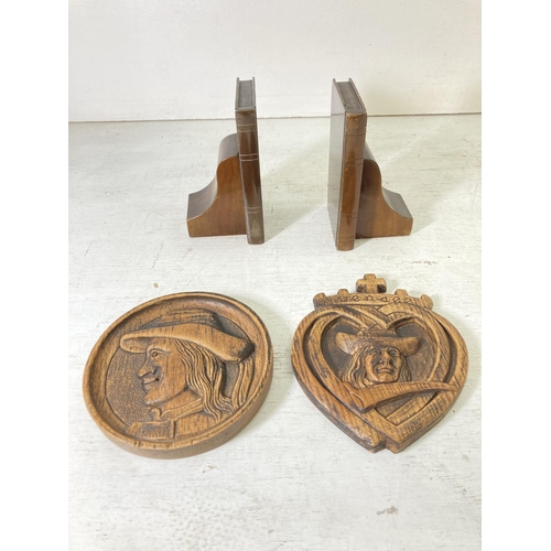 227 - A collection of assorted items to include two carved wooden wall plaques, pair of walnut bookends, b... 