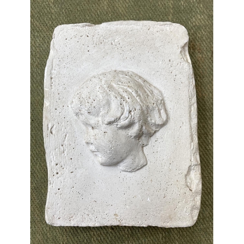 249 - A carved plaster plaque of a young boy - approx. 17cm high x 13cm wide