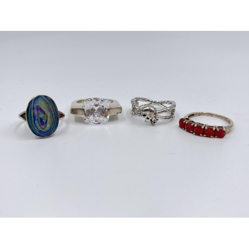 1056 - Four silver rings comprising oval abalone, .925 carnelian, and two .925 CZ stone - approx. gross wei... 