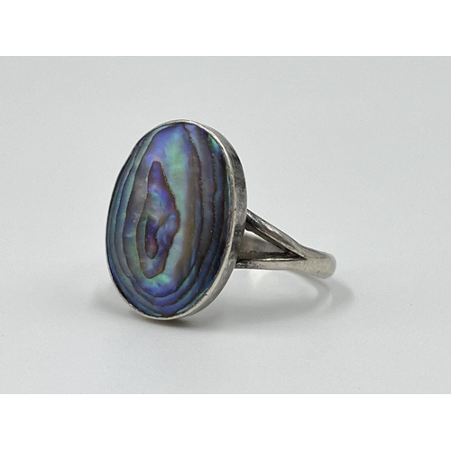 1056 - Four silver rings comprising oval abalone, .925 carnelian, and two .925 CZ stone - approx. gross wei... 