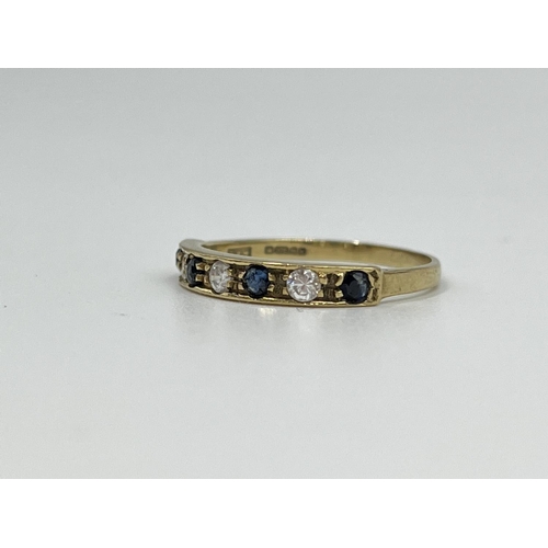 1064 - A hallmarked Birmingham 9ct gold CZ stone and sapphire half eternity ring, size N½ - approx. gross w... 