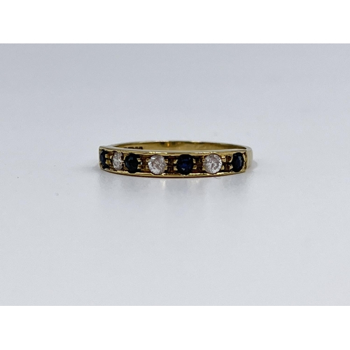 1064 - A hallmarked Birmingham 9ct gold CZ stone and sapphire half eternity ring, size N½ - approx. gross w... 