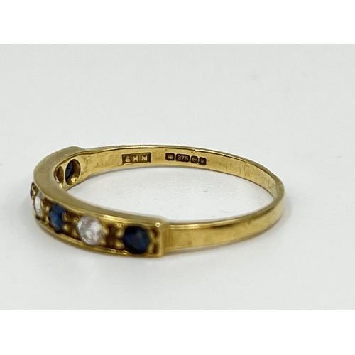 1064 - A hallmarked Birmingham 9ct gold CZ stone and sapphire half eternity ring, size N½ - approx. gross w... 