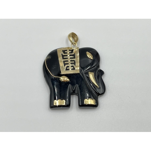 1066 - A black onyx elephant necklace pendant with yellow metal bail and detailing - approx. gross weight 4... 