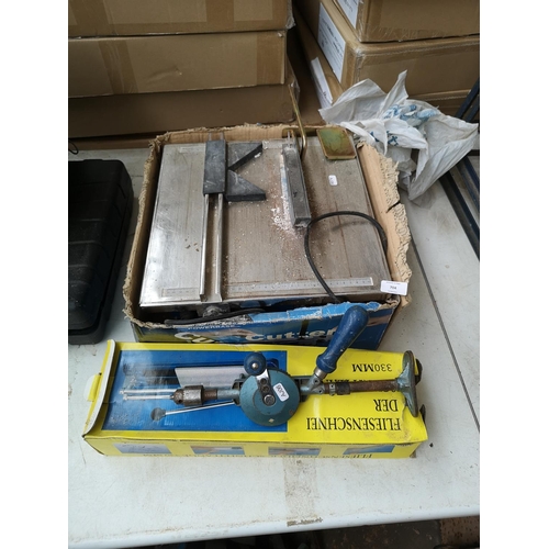 704 - Three tools, one 240v tile cutter, one boxed 230mm hand powered tile cutter and one vintage hand pow... 