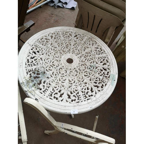 735 - Three cast iron garden items, one pair of garden bench ends and two circular patio tables