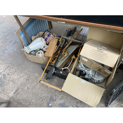 748 - Four boxes containing glass paperweights, antique flat irons, glass bowl, tray, metal detector, lawn... 