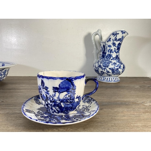 97 - Four pieces of blue and white china, Victoria Ironstone oversized cup and saucer with moustache guar... 