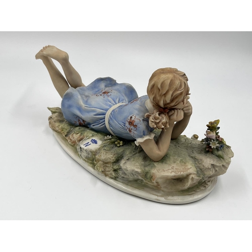 48 - Two Capodimonte figurines, one of a girl lying down signed Sandro Maggioni - approx. 12cm high x 23c... 