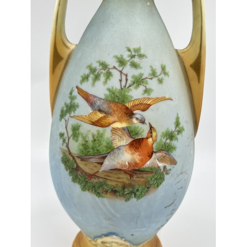 52 - A pair of late 19th/early 20th century Blush Ivory porcelain twin handled vases depicting bird scene... 