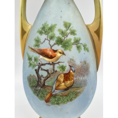 52 - A pair of late 19th/early 20th century Blush Ivory porcelain twin handled vases depicting bird scene... 