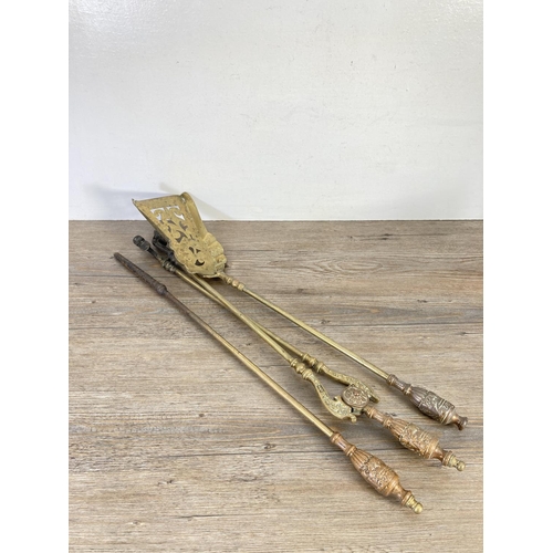 127 - Six pieces of brassware, two fire dogs, three piece companion set and one door handle - approx. 24cm... 