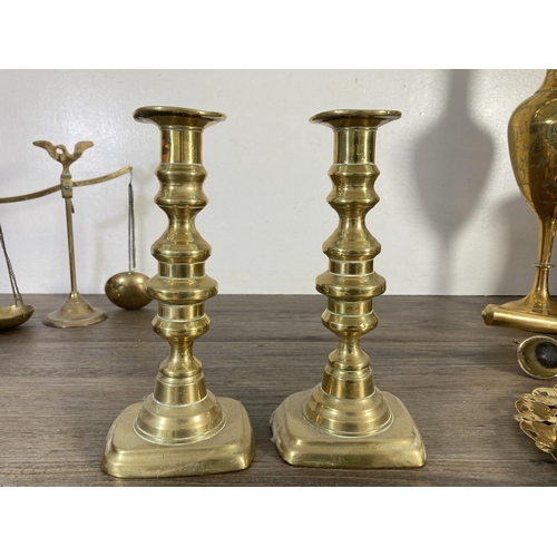 129 - A collection of brassware to include ashtrays, pair of candlesticks, planter, scales etc.