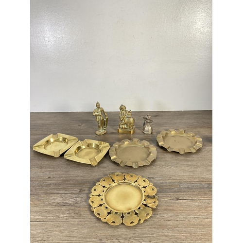 129 - A collection of brassware to include ashtrays, pair of candlesticks, planter, scales etc.