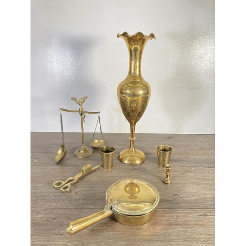 129 - A collection of brassware to include ashtrays, pair of candlesticks, planter, scales etc.