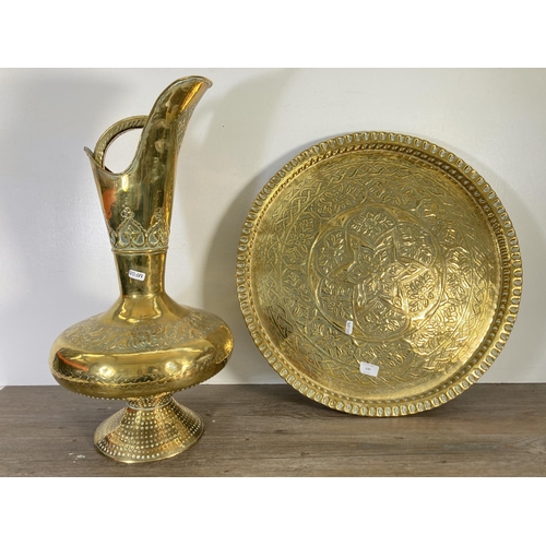 130 - Two pieces of Indian brassware, one 60cm ewer and one 56cm charger