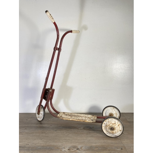 147 - A mid 20th century Tri-ang red metal scooter - approx. 74cm high x 68cm long