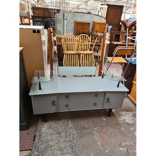 452 - A mid 20th century grey painted dressing table with two central drawers, two outer cupboard doors an... 