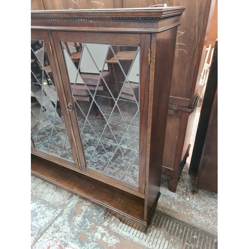 422 - Two pieces of oak furniture, one bookcase with three leaded glass doors and six internal glass shelv... 