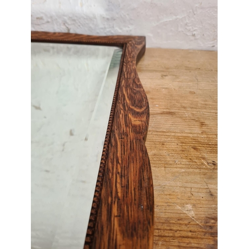 502 - A 1930s oak framed bevelled edge wall hanging mirror - approx. 67cm high x 42cm wide