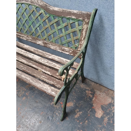 770 - Two pieces of cast iron and wooden garden furniture comprising table - approx. 58.5cm high x 116cm w... 